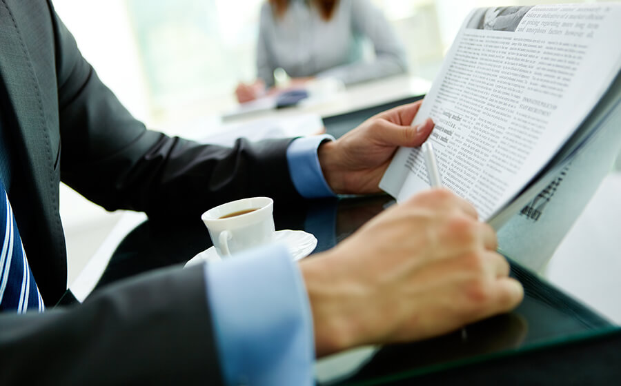 Professional man in suit reading newspaper