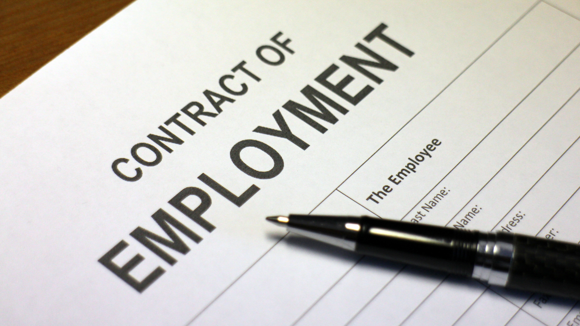 employment rights bill image shows white paper contract of employment with pen on desk