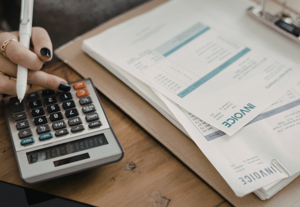 Calculator beside business invoices representing rising UK tax receipts and tax planning for SMEs.
