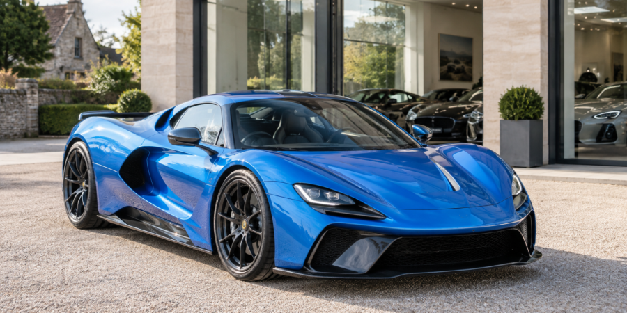 Blue hypercar outside a vehicle showroom, illustrating a business car VAT case